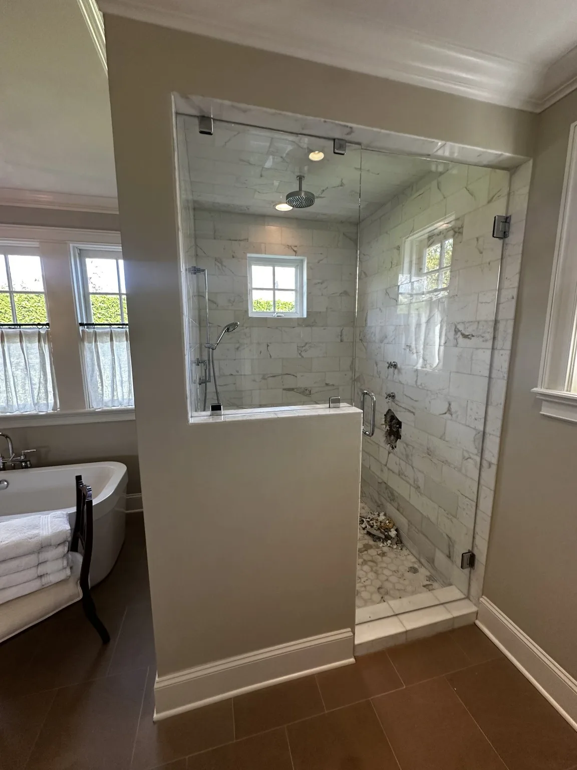 Custom marble-look tile shower with glass enclosure